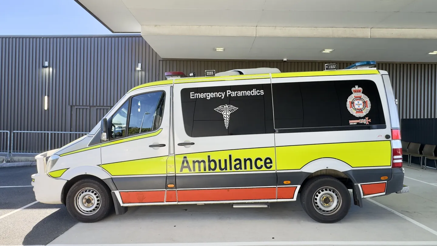 An ambulance parked outside a hospital emergency entrance