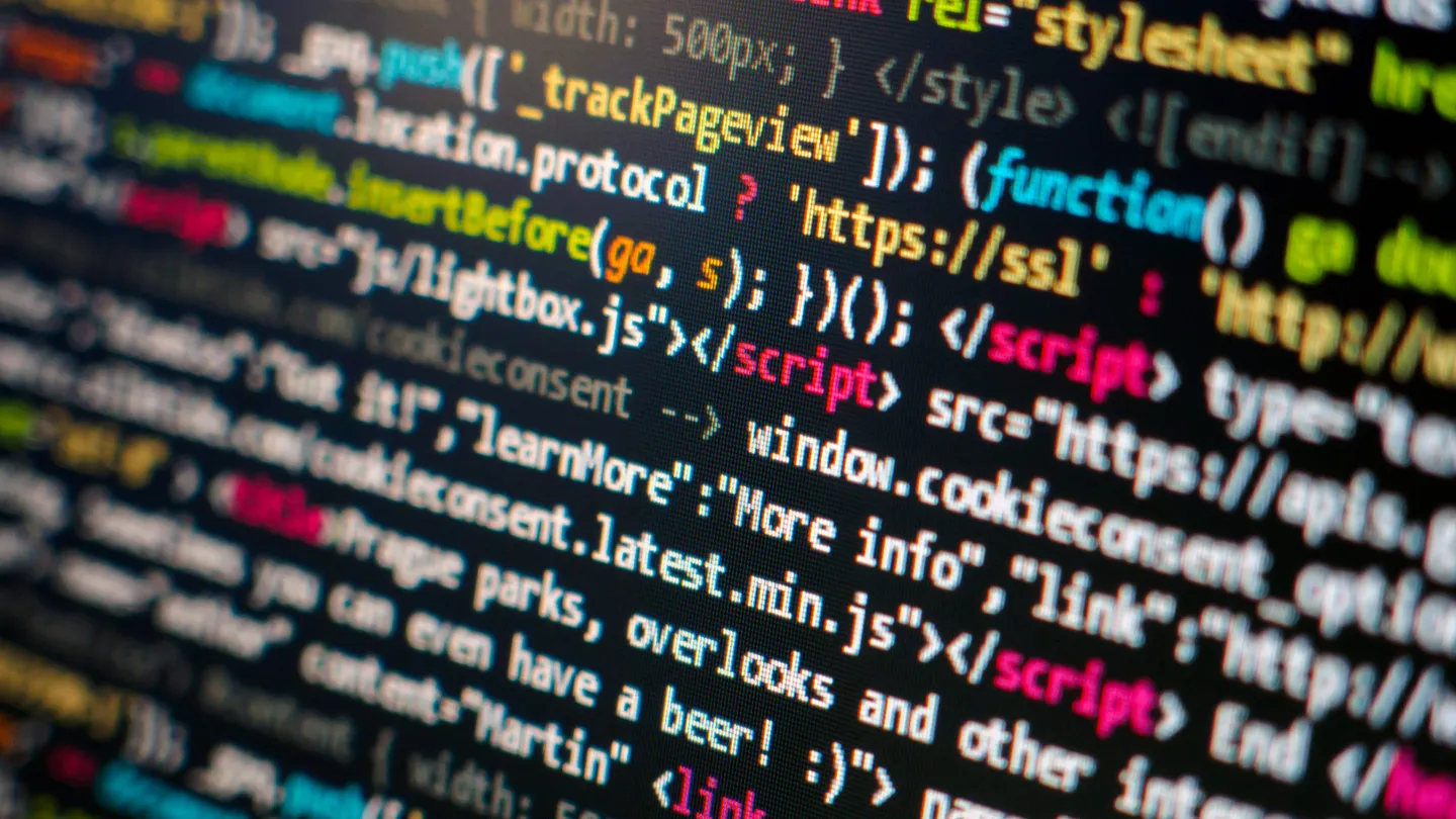 Lines of web page source code glowing on a dark screen